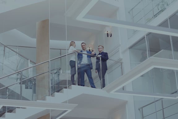 view from below of three people standing on the landing of steps